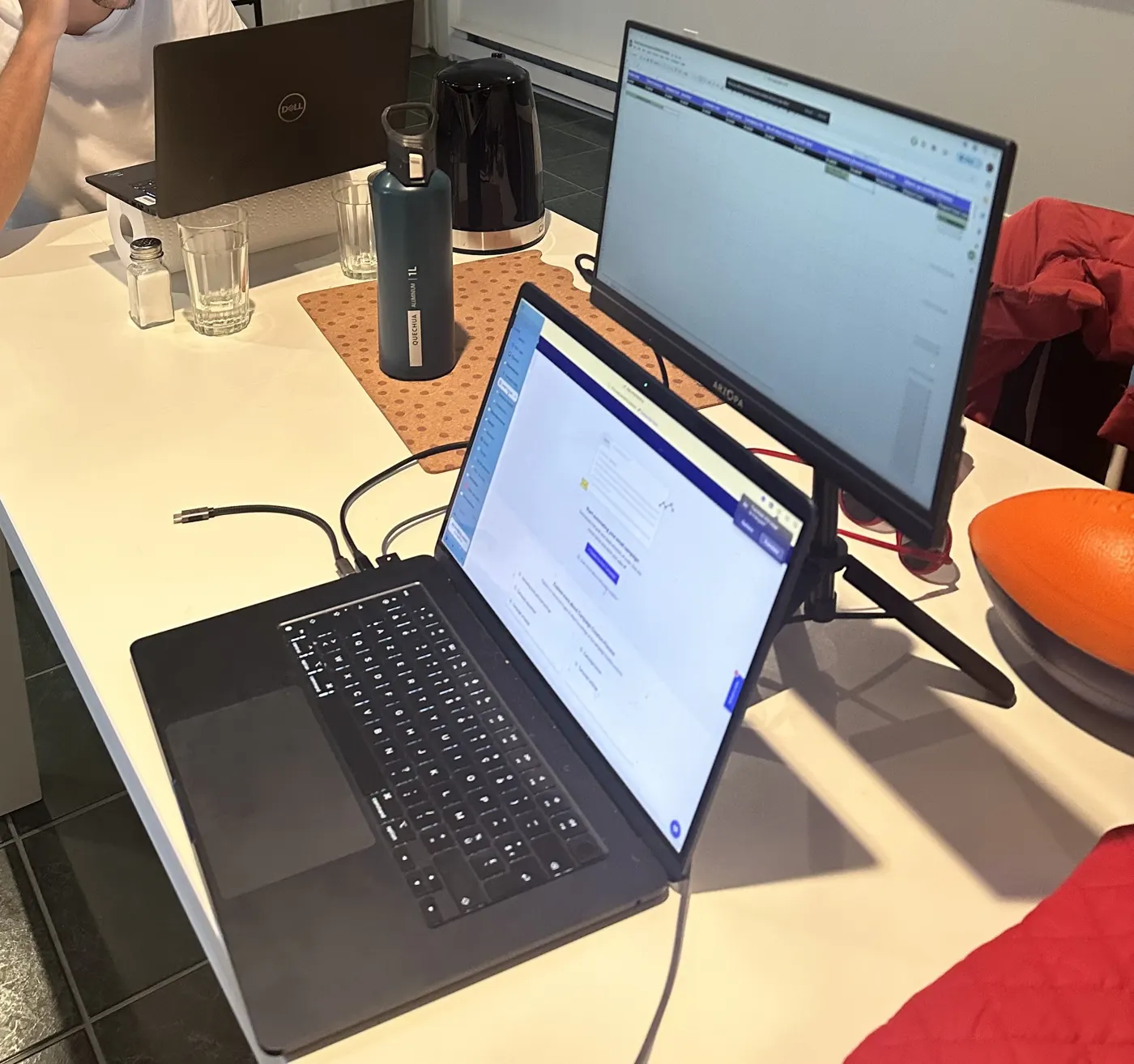 Le setup sur une table : l'ordinateur portable devant, l'écran portable à côté, monté sur le trépied et branché en USB-C